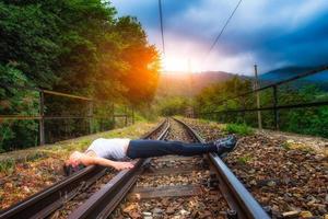 Girl lying on train tracks photo