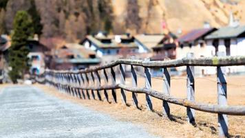 Fence with some typical wooden houses in the background of the village Sils Maria in Switzerland Engadine photo