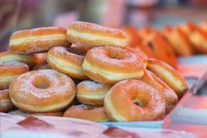 Delicious fresh doughnuts or donuts with sugar topping in a stre photo