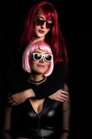 Couple of girls with wig and glasses on black background photo