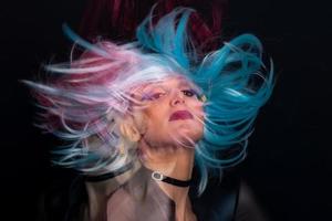 A girl on a black background with triple exposure and hair with three wigs that move photo