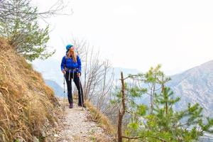 Girl looks the view during a trek in a mountain trail photo