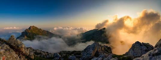 Panoramic of mountains with red colored clouds photo