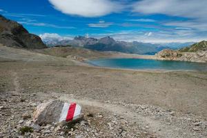 Red mark on stone toward a mountain lake photo