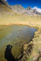 sombra de un fotógrafo en un lago de montaña foto