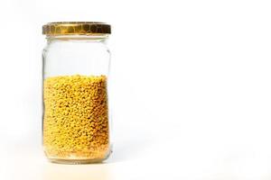 Glass jar with Italian bee pollen on white background photo