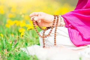 uso de mala con mantras durante una práctica de yoga foto