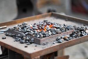 Burning coal in a blacksmiths workshop photo