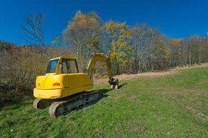 Excavator in a meadow photo