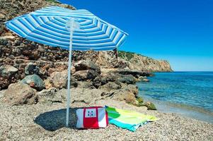 Lonely umbrella at the natural beach of Sardinia in Italy photo