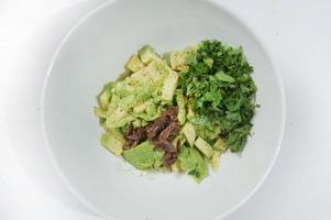 Mediterranean  salad with mix of lettuce leaves and walnuts on a white dish on a wood table with blank space left, italian style, photo