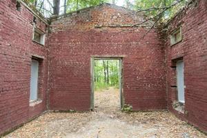 A ruined, brick building in a summer forest, an old and unnecessary building. photo