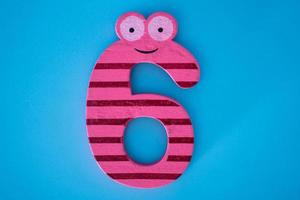Cute and colorful wooden number 6 on a blue background. photo