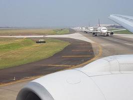 Picture of several airplanes on an airport runway waiting for takeoff clearance photo