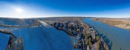 Drone image of wine village Nierstein on the Rhine in blue sky and sunshine with snow covered slopes photo