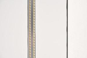 Strip LED light with aluminum profile on white stretch ceiling, modern construction, close up photo