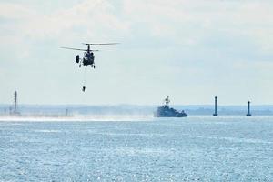 Battleship war ship corvette during naval exercises and helicopter maneuvering over sea, warships photo