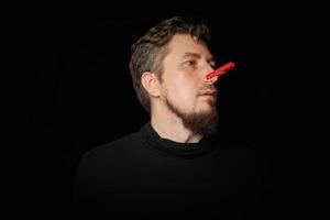 Bearded prankster with clothespin on nose. Funny joke concept. photo