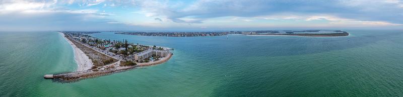 panorama de drones sobre la playa pass-a-grille en la isla del tesoro y el área de pine key en st. petersburgo en florida durante la puesta de sol foto