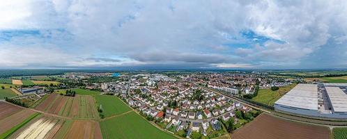 panorama de drones de la ciudad del distrito alemán gross-gerau en el sur de hesse por la noche contra el cielo nublado foto