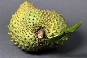 Close up of fresh soursop fruit over black background photo