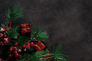 Christmas background eith fir tree branches and gift boxes on dark background. Banner with place for text photo