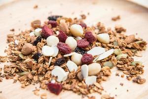 Closed up and blur breakfast healthy food, granola, musli, Organic oat, super food with honey, dried fruits and nuts on wooden plate photo