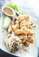 pescado gourami gigante frito con ajo y salsa de marisco, provincia de uthai thani, tailandia