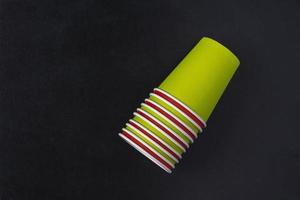 Creative minimalistic composition of inverted paper cups on a black background, coffee, tea, ecology concepts photo