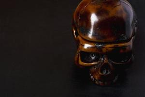 A close-up model of a human skull on a black background, copying space photo