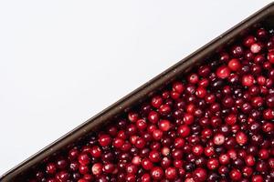 Background of ripe red cranberry berries and white space for copying, top view of cranberry berries photo