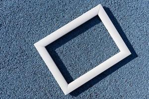 un marco blanco vacío sobre un fondo de textura azul, con un espacio de copia. concepto mínimo foto