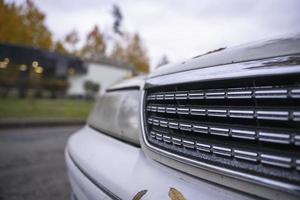 The radiator grille of a classic Japanese car in an autumn urban landscape, a popular Japanese-made sedan photo