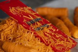 grating carrots on a grater for korean carrots , lifestyle, cooking, healthy eating photo