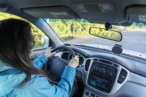 una mujer conduciendo un coche, una mujer joven conduciendo su coche, una vista interior foto
