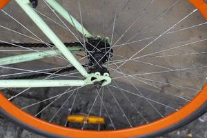 la rueda de una bicicleta de ciudad estacionada contra la pared de un café en la ciudad, yendo en bicicleta al trabajo