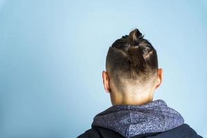 A man with a hairstyle Top Knot or A Man's Bun on a blue background, men's hairstyles, hair care photo