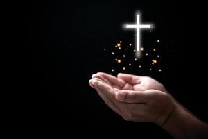 Hands folded in prayer on Holy Bible with cross in church concept for faith, spirituality and religion, Man praying on holy bible withcrucifix in morning. Man hand with Bible and rood praying to god. photo