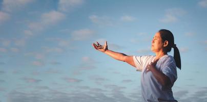 pancarta con espacio de copia de manos de mujer rezando a dios sobre el fondo de la naturaleza. panorama de la adoración de la mujer con fe y amor. concepto de religión, cristianismo, fe, paz, esperanza foto