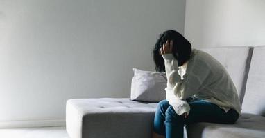 Concept of sad teenage girl depression. Upset teenage girl sitting at window indoors. Anxiety young woman Despair and stress. Lonely and unhappy female are social victims. loneliness youth in home. photo