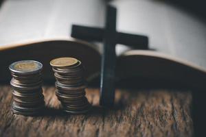 One tenth or tithe is basis on which Bible teaches us to give one tenth of first fruit to God. coins with Holy Bible. Biblical concept of Christian offering, generosity, and giving tithes in church. photo