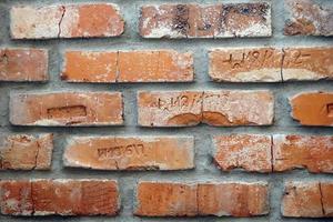 Vintage, Cracked Bricks with Letters on a Wall photo