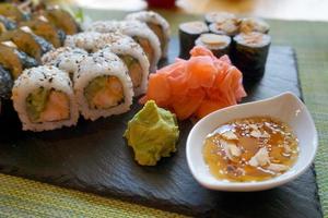 Sliced Rolls of Salmon Sushi with Ginger, Wasabi and Honey Sauce photo