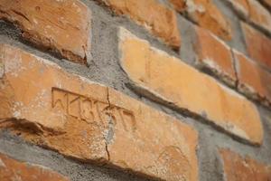 ladrillos antiguos, agrietados con letras en una pared foto