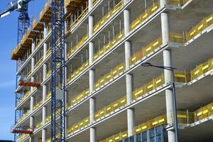 construcción de un edificio de oficinas de varias plantas con pilares de hormigón y grúas foto