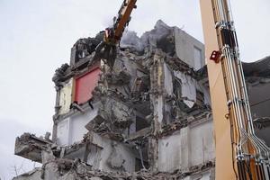 edificio de varios pisos demolido y desmantelado por máquina foto