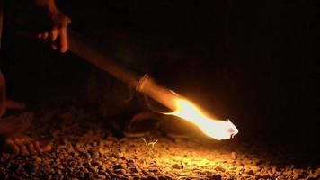 A Flame from the fire torch made by a bamboo stick brightens in the dark night video