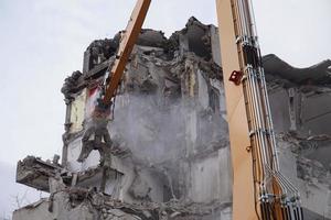 edificio de varios pisos demolido y desmantelado por máquina foto