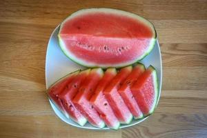 Cut Watermelon on Plate, Wooden Table - Top View photo