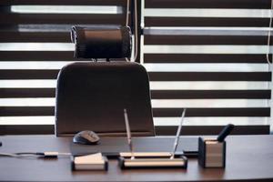 Business office workplace. Work place for chief, boss or other employees. Table and comfortable chair. Light through the half open blinds photo